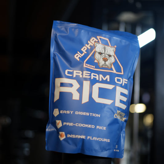 A blue stand-up pouch of Alpha Neon Cream of Rice pre-cooked rice, photographed hanging against a dark, blurred background with bright lights.