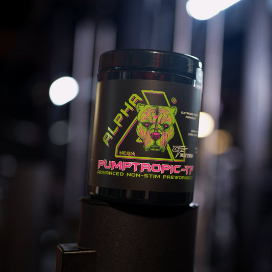 A black tub of Alpha Neon Pumptropic-tf pre-workout supplement with a colorful graphic label, set on a black gym equipment stand in a dark, blurred gym environment.